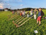Gruppe von Alphornbläser*innen auf einer Wiese
