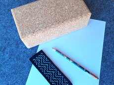 Bleistift und Schleifklotz auf blauem Blatt Papier